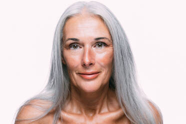 Bild einer schönen älteren Frau, die für eine Beauty-Fotosession posiert. Frau mittleren Alters auf einem farbigen Hintergrund. Konzept über Körperpositivität, Selbstwertgefühl und Körperakzeptanz - DMDF04628
