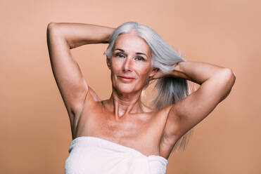Bild einer schönen älteren Frau, die für eine Beauty-Fotosession posiert. Frau mittleren Alters auf einem farbigen Hintergrund. Konzept über Körperpositivität, Selbstwertgefühl und Körperakzeptanz - DMDF04637