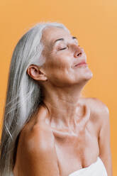 Bild einer schönen älteren Frau, die für eine Beauty-Fotosession posiert. Frau mittleren Alters auf einem farbigen Hintergrund. Konzept über Körperpositivität, Selbstwertgefühl und Körperakzeptanz - DMDF04654