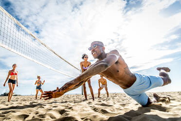 Gruppe von Freunden spielt Beachvolleyball - Multi-ethische Gruppe von Menschen, die Spaß am Strand haben - DMDF04734