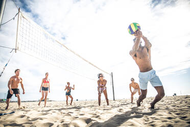 Gruppe von Freunden spielt Beachvolleyball - Multi-ethische Gruppe von Menschen, die Spaß am Strand haben - DMDF04735