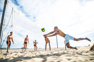 Gruppe von Freunden spielt Beachvolleyball - Multi-ethische Gruppe von Menschen, die Spaß am Strand haben - DMDF04737