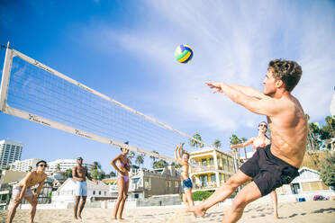 Gruppe von Freunden spielt Beachvolleyball - Multi-ethische Gruppe von Menschen, die Spaß am Strand haben - DMDF04738