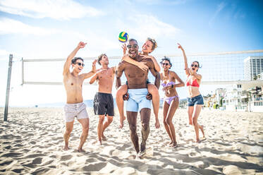 Gruppe von Freunden spielt Beachvolleyball - Multi-ethische Gruppe von Menschen, die Spaß am Strand haben - DMDF04742