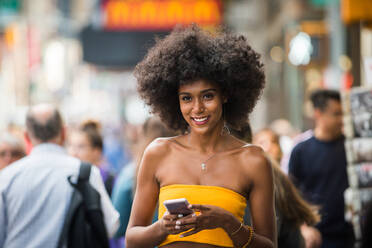 Happy african american woman smiling. Beautiful young female walking and having fun in New York city - DMDF04750