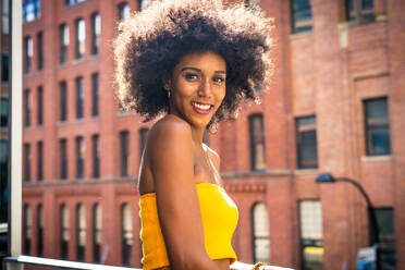 Happy african american woman smiling. Beautiful young female walking and having fun in New York city - DMDF04781