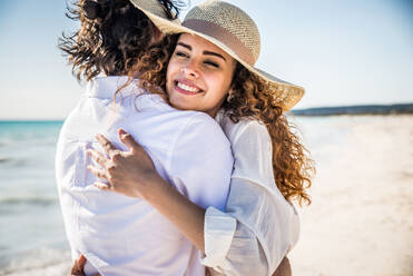 Couple strolling at the beach and smiling - Young adults enjoying summer holidays on a tropical island - DMDF04802