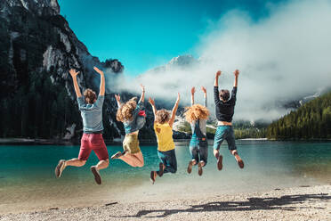 Group of friends having a walk on a mountain lake - Young people exploring the nature - DMDF04810