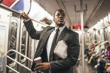 Geschäftsmann in vollem Anzug in der New Yorker U-Bahn - DMDF04834