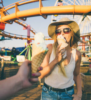 Two young women eating ice cream of Santa Monica pier and having fun - DMDF04847