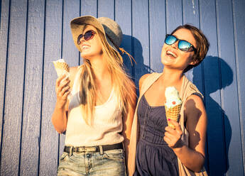 Two young women eating ice cream of Santa Monica pier and having fun - DMDF04850