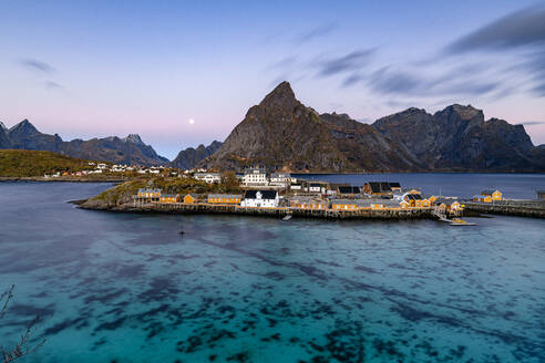 Sunrise over Olstind mountain and fishing village of Sakrisoy overlooking the cold blue sea, Lofoten Islands, Nordland, Norway, Scandinavia, Europe - RHPLF27577