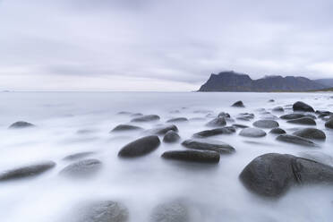 Clouds at dusk over rocks washed by the Arctic sea at Uttakleiv beach, Vestvagoy, Lofoten Islands, Nordland, Norway, Scandinavia, Europe - RHPLF27590