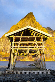 Fishing racks overlooking the cold sea with Olstind mountain peak on background, Sakrisoy, Reine, Lofoten Islands, Nordland, Norway, Scandinavia, Europe - RHPLF27608