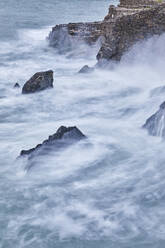 On a rising tide, evening surf pounds the historic harbour wall at Hartland Quay, on the Atlantic coast of Devon, England, United Kingdom, Europe - RHPLF27929