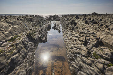 A sparkling sunlit shoreline pool on the Atlantic coast at low tide, Welcombe Mouth, a cove in the Hartland area of north Devon, England, United Kingdom, Europe - RHPLF27961