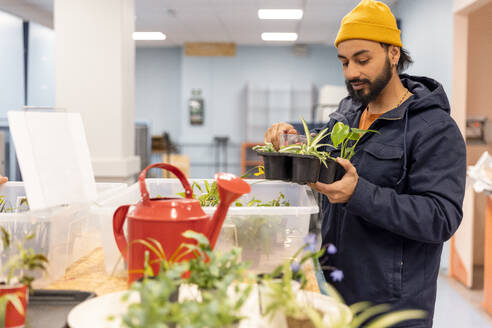 Männlicher Kunde mit Jacke beim Kauf von Pflanzen im Recyclingzentrum - MASF38469