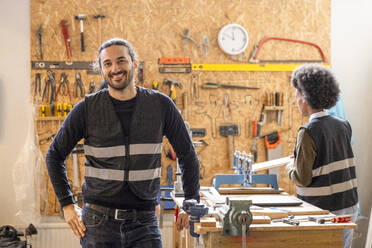 Porträt eines selbstbewussten männlichen Technikers, der mit der Hand auf der Hüfte im Recyclingzentrum steht - MASF38483