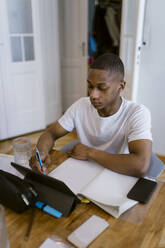 Junger Mann lernt mit digitalem Tablet zu Hause - MASF38520