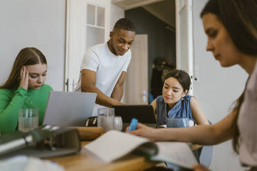 Junger Mann studiert mit Freundinnen zu Hause - MASF38527