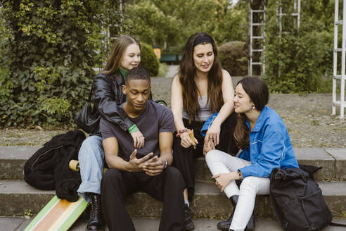 Young friends talking while sitting on steps - MASF38589