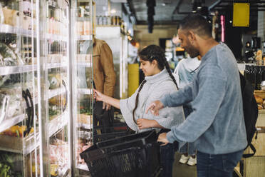 Smiling father and daughter buying grocery at convenience store - MASF38598