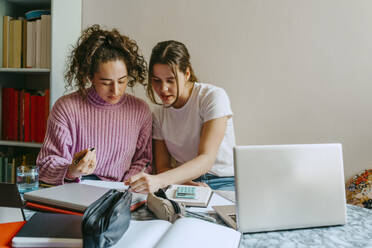 Young female friends helping each other with homework - MASF38719