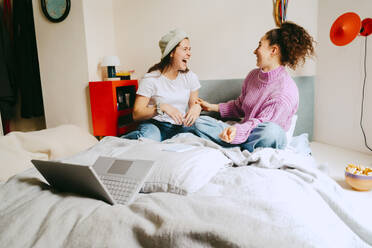 Cheerful female friends spending leisure time together at home - MASF38772