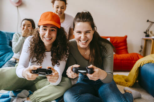 Young female friends enjoying video game at home - MASF38821