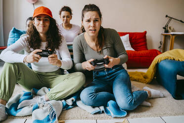 Young female friends playing video game at home - MASF38823
