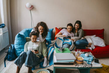 Young female friends using mobile phones at home - MASF38838