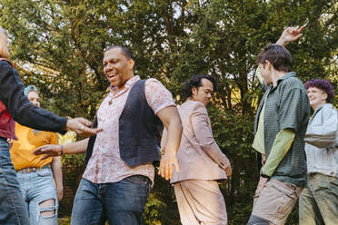 Friends of LGBTQ community dancing with each other during party in back yard - MASF39001