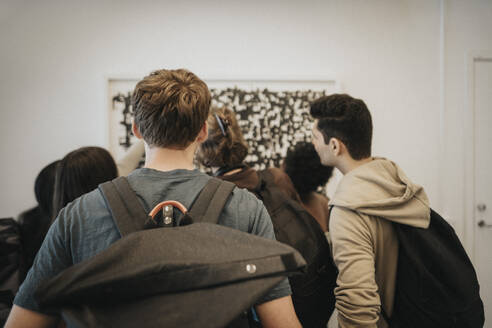 Rear view of students checking result on bulletin board in university - MASF39117