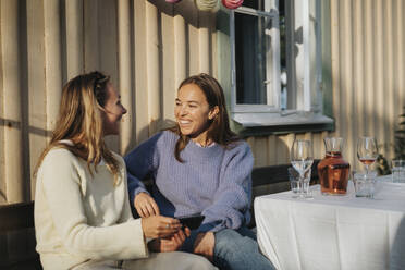 Glückliche junge Frauen, die sich während einer Dinnerparty im Café unterhalten - MASF39195