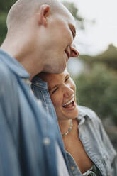 Young woman laughing with male friend during dinner party at cafe - MASF39221