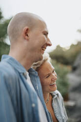 Man and woman laughing together during dinner party at cafe - MASF39222