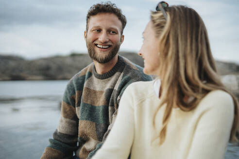 Glücklicher junger Mann genießt mit Freundin in der Nähe des Sees - MASF39236