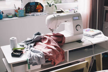 Sewing machine with clothes on table - MASF39370