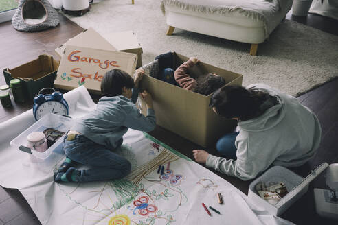 Mutter mit Sohn Zeichnung auf Karton im Wohnzimmer zu Hause - MASF39389
