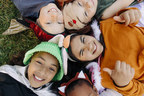 Directly above shot of happy kids lying on grass at summer camp - MASF39409