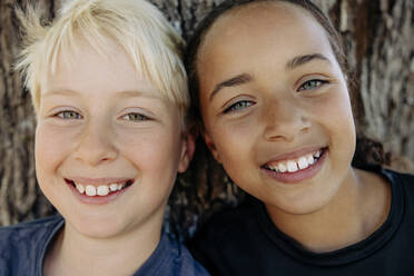 Porträt eines lächelnden blonden Jungen mit einer Freundin im Ferienlager - MASF39415