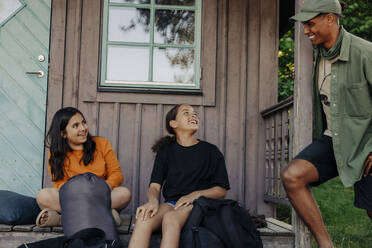Lächelnde Mädchen im Gespräch mit einem männlichen Betreuer in der Nähe der Hütte im Ferienlager - MASF39439