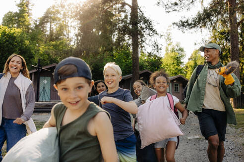 Excited kids and counselors running together at summer camp - MASF39442