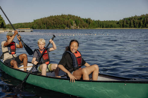 Kinder haben Spaß beim Kajakfahren mit Betreuern auf dem See im Sommercamp - MASF39456