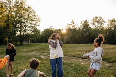 Kinder haben Spaß beim Spielen mit einer Betreuerin auf dem Spielplatz im Ferienlager - MASF39526