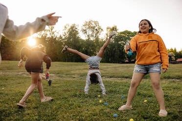 Carefree kids enjoying together while playing in ground at summer camp - MASF39529