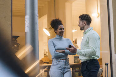 Happy young businessman talking to colleague outside cafe - JOSEF21012