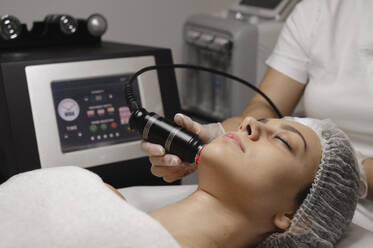 Dermatologe führt Rf-Lifting-Verfahren am Gesicht einer Frau durch - ALKF00630
