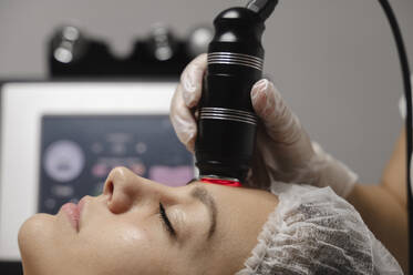 Dermatologe beim Rf-Lifting am Gesicht einer Frau in der Klinik - ALKF00632