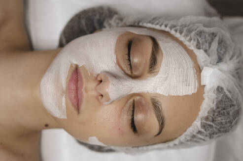 Frau entspannt sich mit Gesichtsmaske im Schönheitssalon - ALKF00636